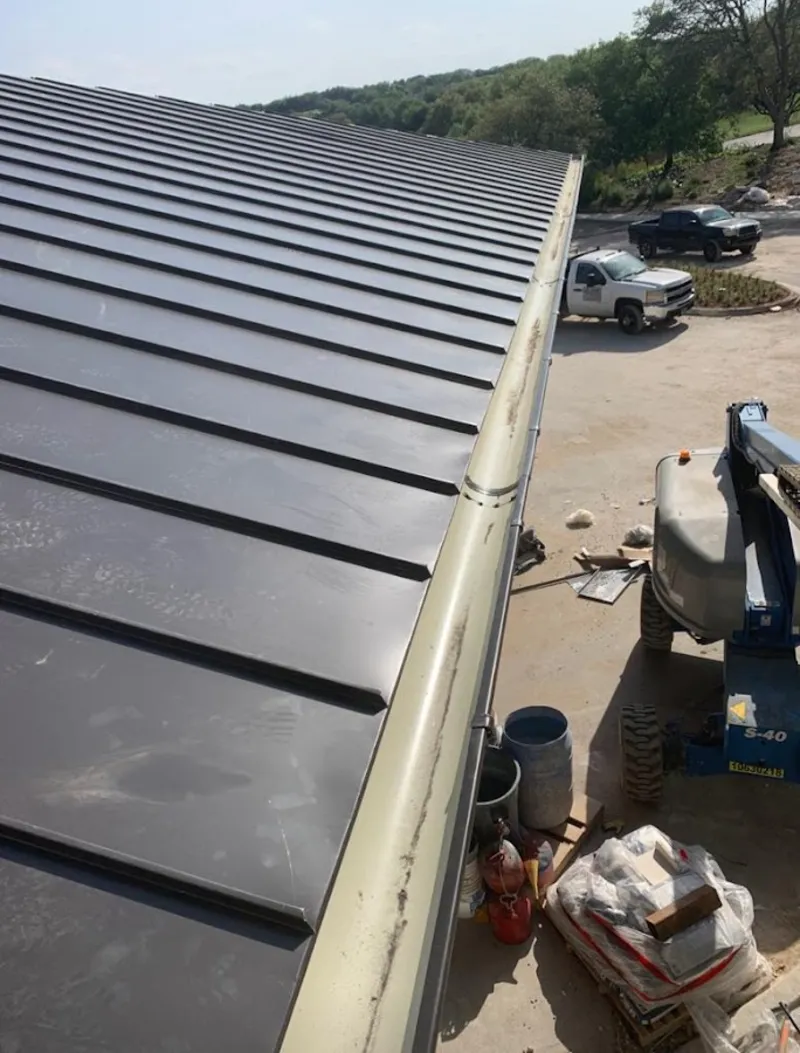 Standing seam panel and gutter detail on a metal roofing jobsite in Saks